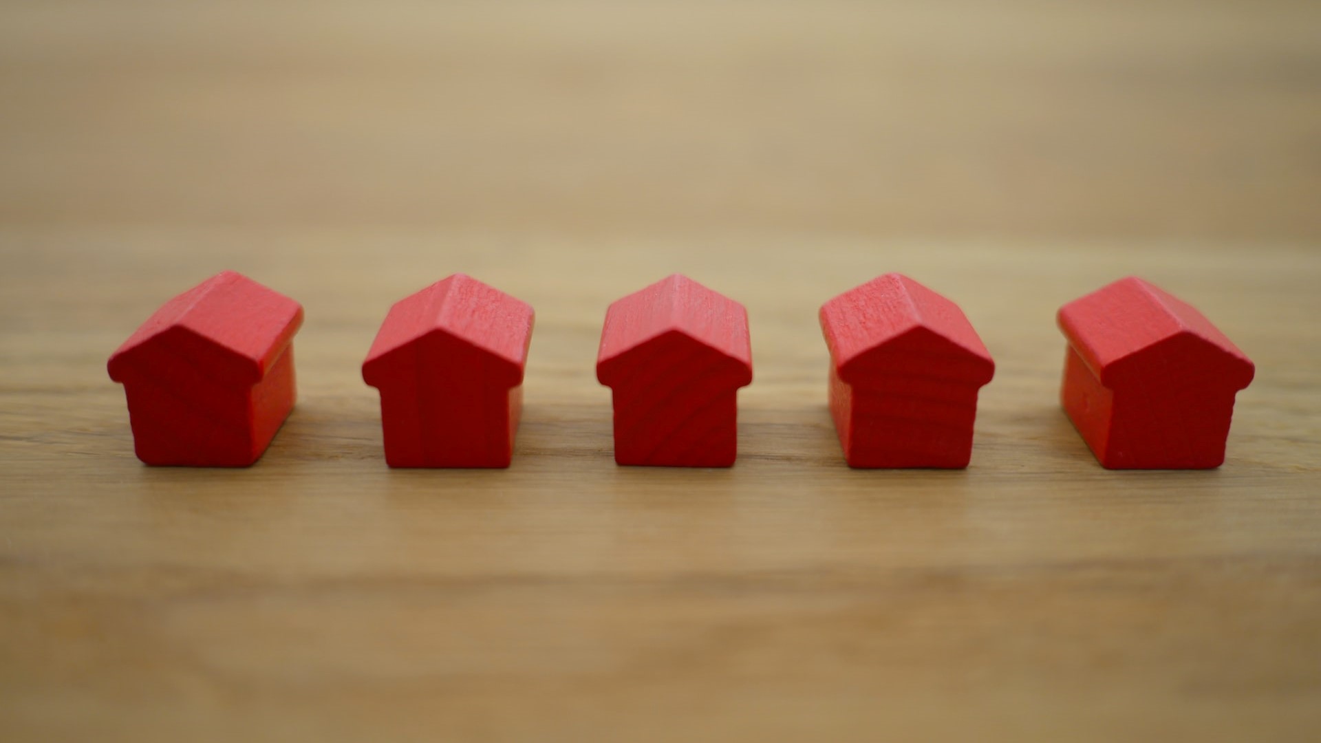 A row of wooden red figurine houses.