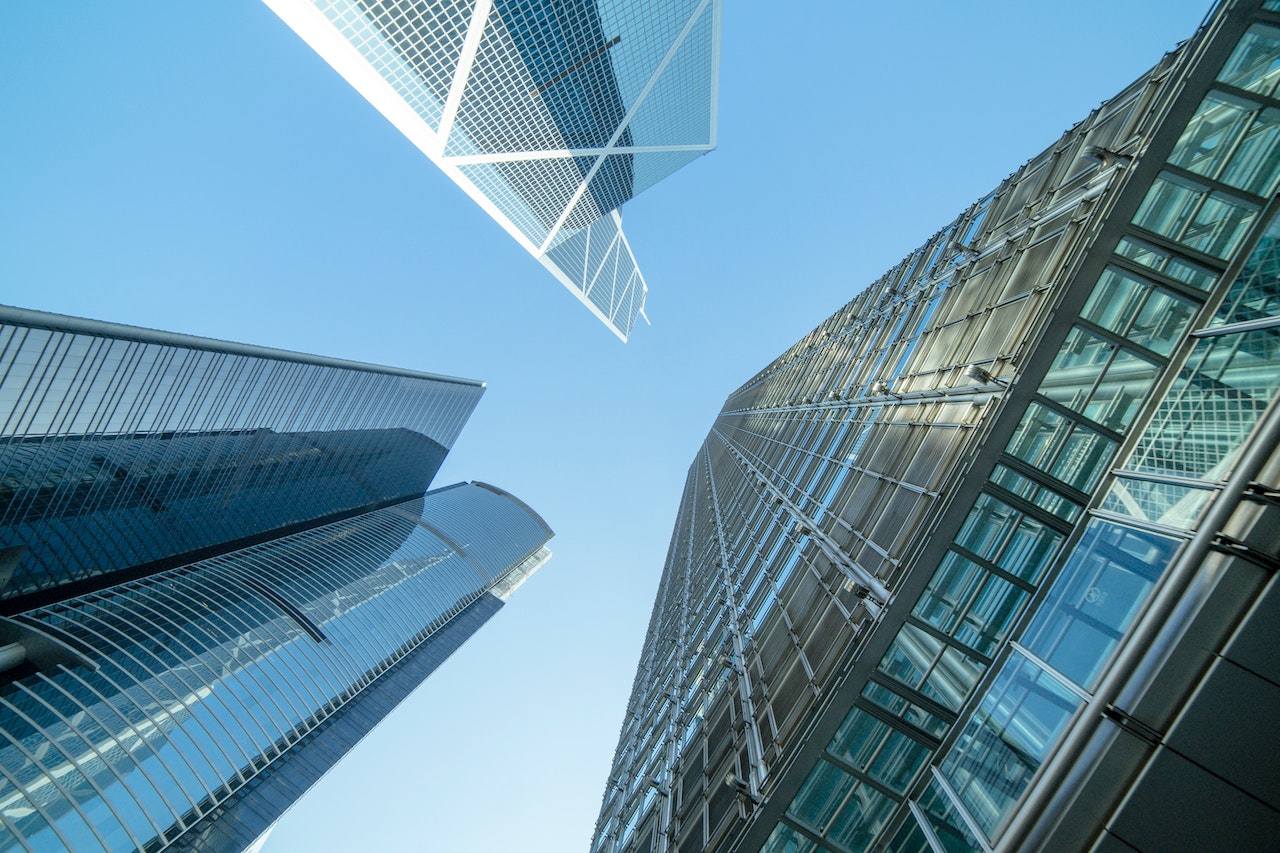 Low-angle photography of commercial buildings under a blue and white sky