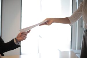 A person handing over paperwork